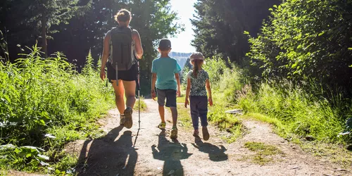 Frau mit Kindern auf Wanderweg im Sommer