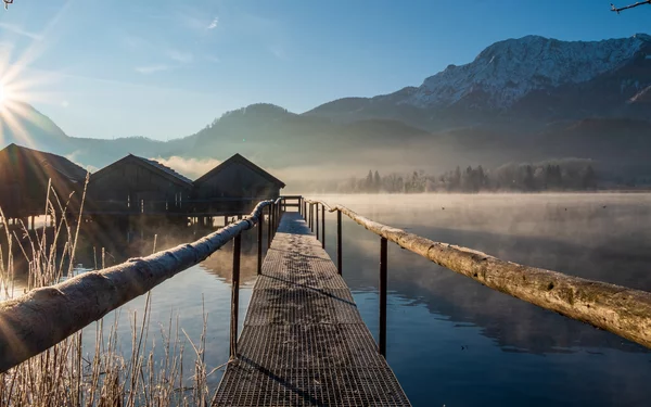 Steeg mit Hütten am winterlichen Kochelsee