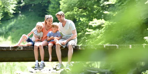 Junge Familie, die auf einem Steg sitzt